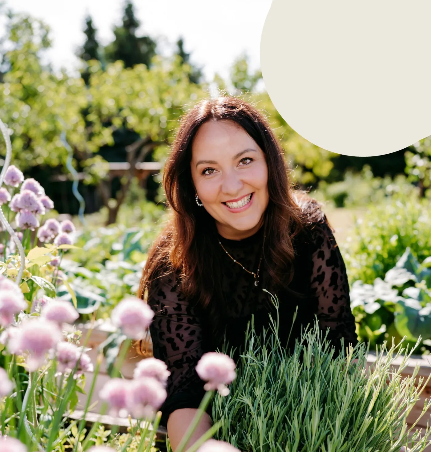Saskia von Elli’s Landliebe lächelt im Garten, zwischen Lavendel und blühendem Schnittlauch